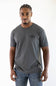 A man wearing a dark gray crewneck t-shirt with a small black chest logo that reads 'Ariat', paired with blue jeans, standing against a plain white background.