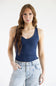 A woman modeling a dark navy blue tank top paired with light-wash denim jeans against a plain white studio background.