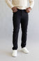 Man wearing black pants and white shoes on a plain background