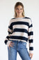 Front view of a model wearing the Just Polly long-sleeve knit sweater featuring wide light pink and navy blue horizontal stripes accented with thin heather grey stripes, a boat neckline, and ribbed cuffs, styled with denim jeans against a plain white background.