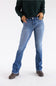 A person wearing medium-wash blue jeans, a dark green cable-knit sweater, and brown ankle boots, standing against a plain white studio background.