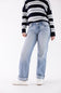 A model wearing light-wash blue straight-leg jeans, a navy and white striped sweater, and white sneakers, shown from the chest down against a plain white studio background.