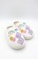 A pair of white sherpa slip-on slippers decorated with colorful embroidered majong and fan motifs on the sides, shown on a clean white background.