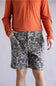 Marsh Wear Prime Hagood 8” Shorts for Men in Green Mallard Camo; Person wearing an orange long-sleeve shirt and camouflage shorts on a plain background