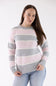 A woman modeling the Pink Rose Drop Shoulder Striped Knit Sweater in light pink, grey, and white horizontal stripes, featuring a crew neckline and drop shoulders.