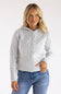 A woman wearing a light gray cable-knit hooded cardigan sweater with blue jeans, standing against a plain white studio background.