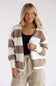 A blonde woman modeling a long-sleeve knit cardigan featuring bold white and tan horizontal stripes, layered over a black scoop-neck shirt and light beige drawstring pants.