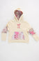 Front view of a girls' cream-colored pullover hoodie featuring an embroidered pink ribbon bow on the chest, a pink quilted patterned kangaroo pocket, patchwork floral elbow patches, and a patterned hood lining against a plain white background.