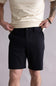 Person wearing black shorts and a beige shirt on a plain background. The shorts are the Quiksilver Taxer Amphibian 18" Hybrid Shorts for Men in Black