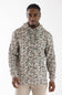 A man wearing a camouflage-patterned pullover hoodie in shades of beige, brown, and gray, paired with beige pants, photographed against a plain white studio background.
