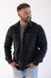 man wearing a plaid shacket with his hands tucked in his front pockets