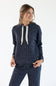 A woman modeling a dark navy blue ribbed knit loungewear set, featuring a hooded sweatshirt with cream-colored textured drawstrings and matching knit pants, against a plain white studio background.