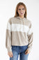 A woman wearing a color-blocked knit hoodie with beige, white, and taupe horizontal stripes, paired with blue jeans, against a plain white studio background.