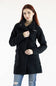A woman with red hair wearing a black textured teddy coat and blue jeans, standing against a plain white studio background. The brand name 'COLUMBIA' is visible on the left chest of the coat.