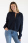 Front view of a female model wearing the Things Between Alyssa Cardigan in Navy, featuring a crew neckline, large front buttons, ribbed hem, and long sleeves paired with blue jeans.