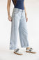 Three-quarter view of Aaron & Amber High Rise Sideseam Detail Wide Leg Jeans in Light Denim, styled with retro low-top sneakers against a plain white background.