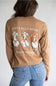 A brown long-sleeve t-shirt with a graphic of three western-style geese on the back, featuring the text 'JUST A SILLY GOOSE' and 'simply southern.' on the back, and 'simply southern.