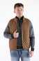 Man wearing a brown rhombus quilted field vest over a gray mock-neck pullover and jeans.