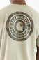 Close-up of the back of a person wearing a light beige Carhartt T-shirt with a large circular camouflage graphic and the words CARHARTT BUILT TO LAST printed in white.
