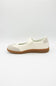 A single Mary Jane shoe in off-white and light beige with a brown gum sole, shown in profile against a light gray background.