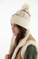 Model wearing a Carhartt thick knit cuffed beanie with a pom-pom in Oat Milk