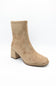 A single beige suede ankle boot with a chunky block heel and square toe, photographed from a three-quarters angle on a white background.