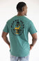 A man wearing a teal green t-shirt with a large back graphic that reads 'MARSH WEAR' and features a yellow deer and black text, shown from behind against a white background.