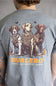 A person viewed from the back wearing a heather gray t-shirt with a large graphic print of three dogs in camouflage hunting vests and the text 'BURLEBO OUTDOORS' in orange and white.