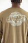 A close up of a man viewed from the back wearing a long sleeve light brown t-shirt with a graphic that says "CARHARTT BUILD BY HAND MADE WITH HEART" with a Carhartt logo C.