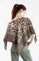 A woman with red hair tied back is shown from behind wearing a brown and beige patterned scarf draped over her shoulders, paired with olive green pants, against a plain white background.