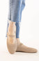 Side profile and front view of a model wearing beige knit mesh Mary Jane flats paired with light blue frayed denim jeans.
