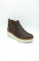 A dark brown leather Chelsea-style ankle boot with elastic side gore panels and a thick cream-colored wedge sole, shown on a white studio background.