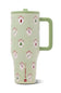 A light green HydroJug travel mug with a matching lid and handle, decorated with a festive pattern of red stockings, Christmas trees, and white snowflakes over vertical light green stripes.