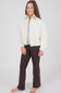 girl modeling a white jacket with matching brown flare leggings