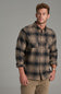 A man wearing a long-sleeve plaid button-up shirt in brown and beige tones, paired with khaki pants, standing against a solid gray studio background.