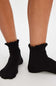 Black ruffled socks worn by a person on a white background