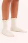 White socks with lace trim worn by a person on a white background