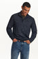 A man wearing a dark navy and black textured quarter-zip sweater with blue jeans, standing against a plain white background.
