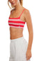 FP Movement Tighten Up Reversible Bra for Women in Grapefruit Combo; Woman wearing a red and pink striped sports bra and white pants on a white background