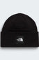 A black ribbed knit beanie hat featuring a black square patch on the front with the white 'THE NORTH FACE' logo, set against a light gray background.
