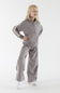 Young girl posing in a heather cocoa two-piece outfit featuring a long-sleeve half-zip mock-neck pullover with contrast stripe detail on the sleeves and matching wide-leg pants.