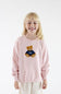 A young girl with blonde hair smiling while wearing a light pink crewneck sweatshirt with an embroidered teddy bear wearing a navy blue jersey with the number 98.