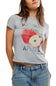 A woman wearing a light gray heathered graphic t-shirt with a distressed red apple print and the words 'MICHIGAN APPLES', paired with blue jeans.