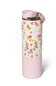 A reusable insulated tumbler with a light pink base and lid, featuring a white floral patterned wrap around the middle with pink, yellow, and orange flowers.