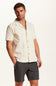 Weatherproof Vintage Bandana Camp Shirt for Men in Tan; Man wearing a beige short-sleeve shirt and gray shorts on a white background