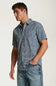Weatherproof Vintage Poplin Button Up Shirt for Men in Teal; Man wearing a short-sleeve patterned shirt and jeans on a plain background