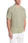 Weatherproof Vintage Cotton Airtex Shirt for Men in Seagrass; Man wearing a light green short-sleeve button-up shirt with white pants on a white background