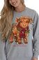A woman wearing a heather gray crewneck sweatshirt with a graphic of a brown Scottish Highland cow wearing a red plaid scarf and holiday lights, with the text 'simply southern' below.