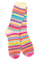 A pair of long knit socks with a vibrant multicolor Fair Isle pattern featuring pink, yellow, blue, and white stripes, displayed against a solid white background.