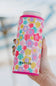 A can cooler with a colorful floral pattern in pink, yellow, teal, and purple, featuring the brand name KATYDID near the bottom.